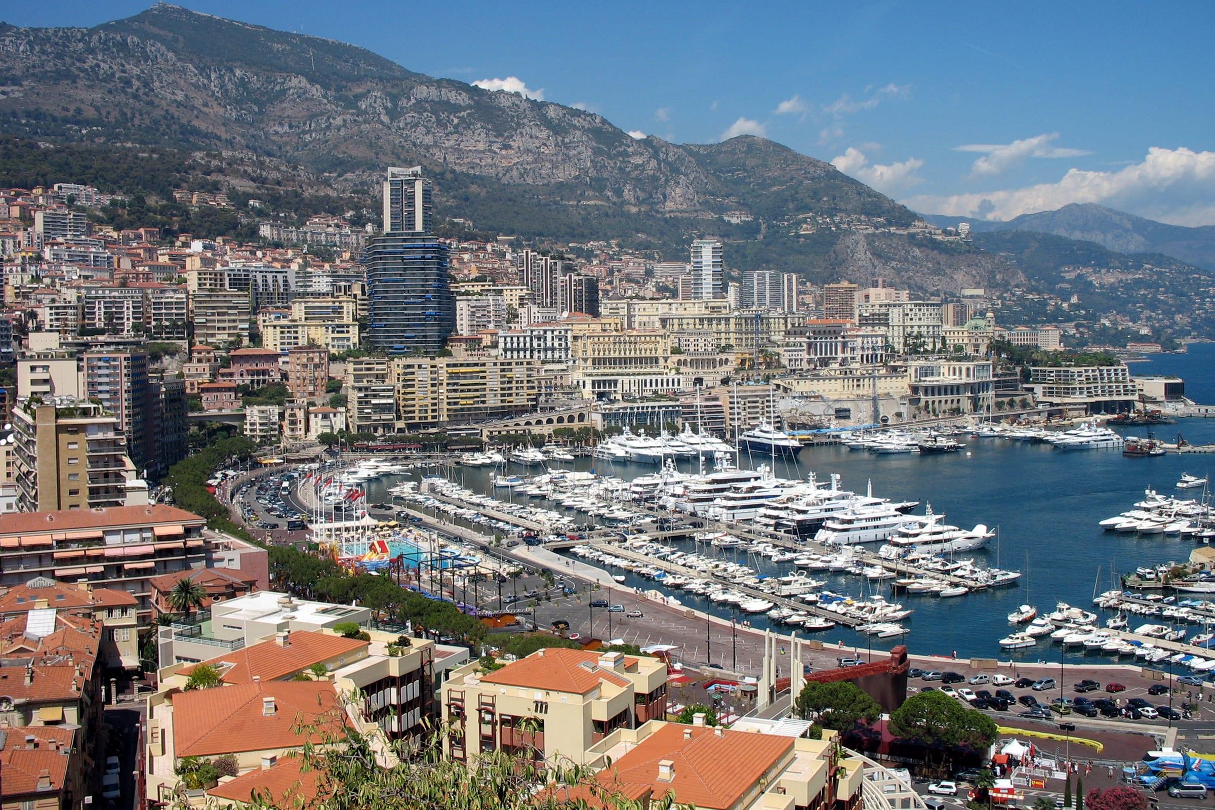 Monte Carlo rising above Port Hercule, harbour and hillside apartments in view.